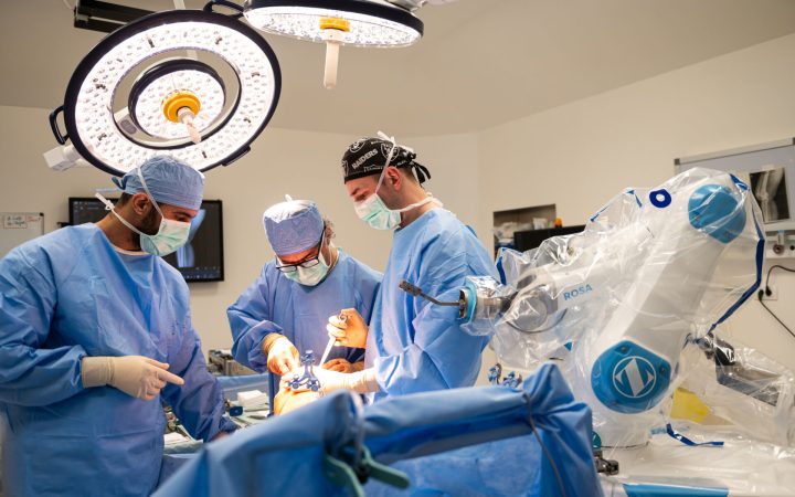 Prof. univ. dr. Radu Prejbeanu, medic primar chirurg ortopedie și traumatologie, coordonatorul Centrului de Excelență în Chirurgia Ortopedică și director medical al Spitalul Premiere, Timișoara în timpul intervenției chirurgicale pentru o endoprotezare pe baza chirurgiei asistate robotic de către sistemul ROSA Knee.