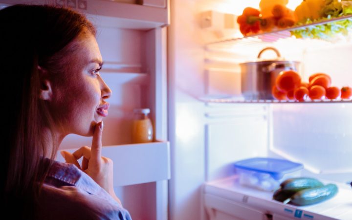 femeie alege alimente din frigider pentru cină