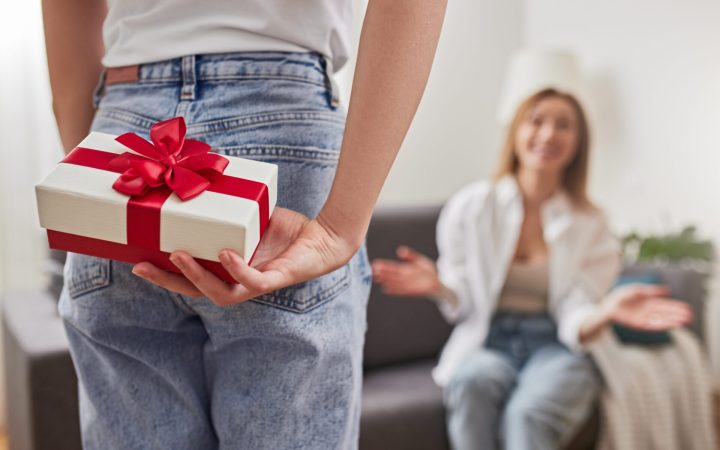 tânără ascunde la spate un cadou pentru prietena ei