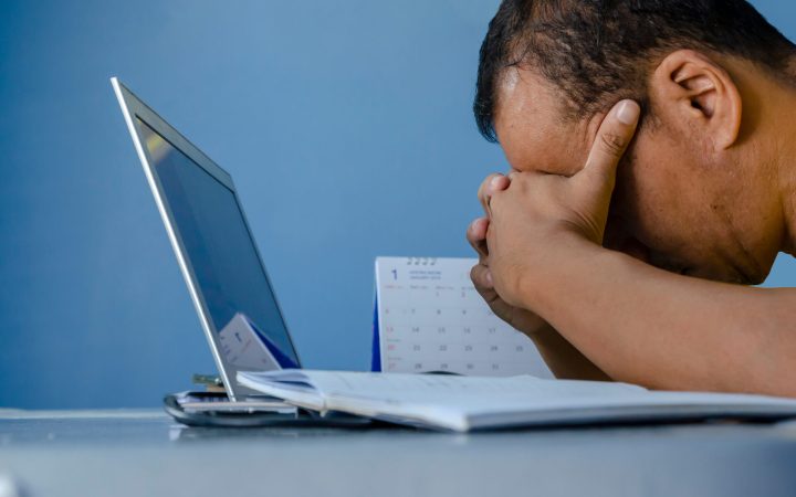bărbat trist la laptop, de blue monday, fundal albastru și calendar în spate