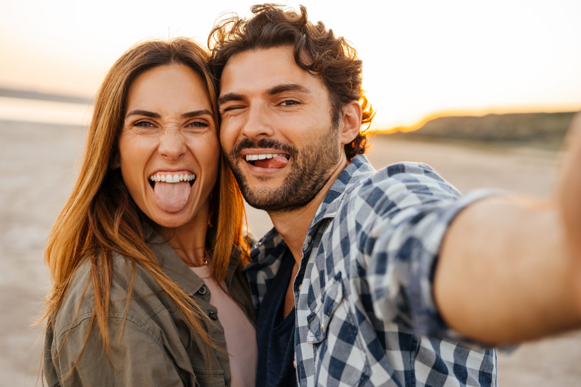 joaca în cuplu - tineri care râd, scot limba și fac selfie împreună