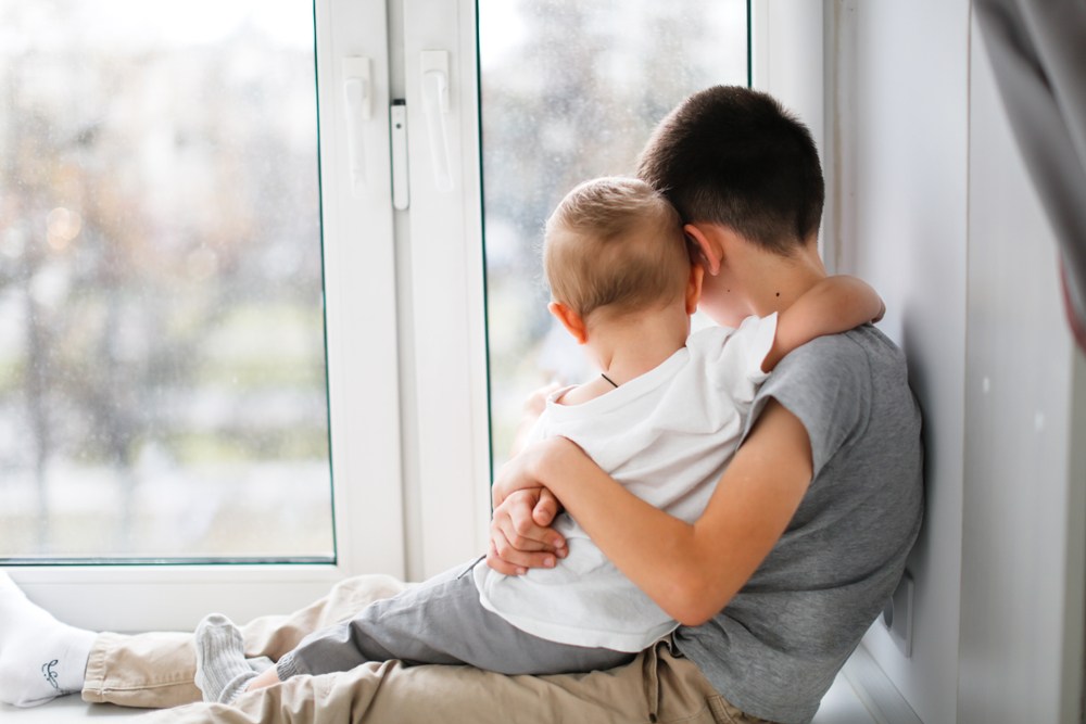 Copil parentificat - băiețel având grijă de fratele lui